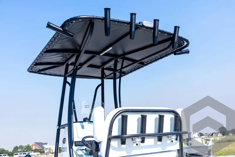 Slide: The Image of 2026 Pathfinder 2200 TRS boat with T-top and rod holders, clear sky background. - 27