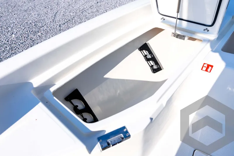 Slide: The Image of Open storage compartment on 2026 Pathfinder 2200 TRS boat, featuring cup holders and fire extinguisher label. - 40