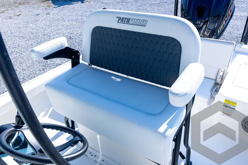 Slide: The Image of 2026 Pathfinder 2200 TRS boat seat with armrests and steering wheel, outdoor setting. - 62