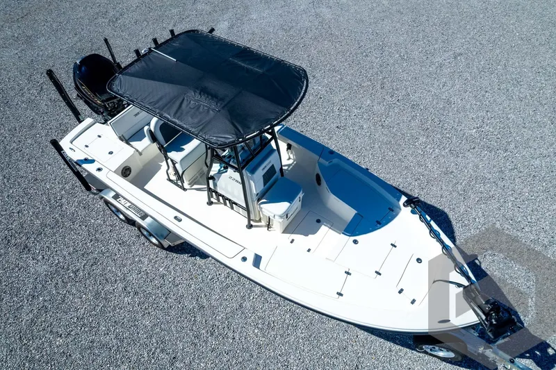 Slide: The Image of Aerial view of 2026 Pathfinder 2200 TRS boat with T-top on gravel surface. - 83