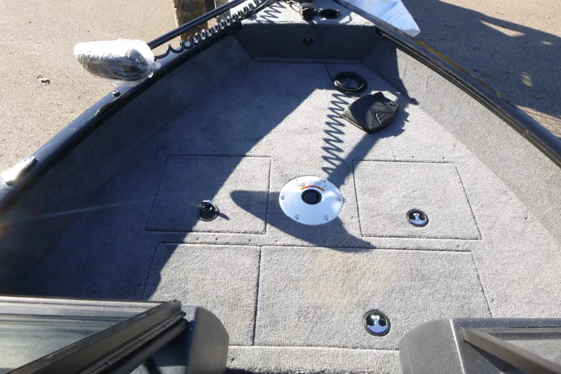 Slide: The Image of 2026 Tracker Pro Guide V-16 WT boat interior with carpeted deck and storage compartments. - 6