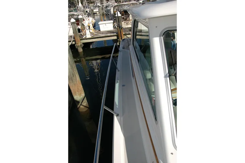 Slide: The Image of 2015 Back Cove 37 yacht docked at marina, side view with railing and windows. - 27