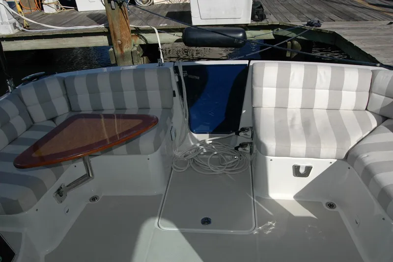Slide: The Image of 2015 Back Cove 37 boat interior with striped seating and wooden table. - 29