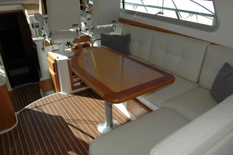 Slide: The Image of 2015 Back Cove 37 yacht interior with cushioned seating and wooden table. - 38