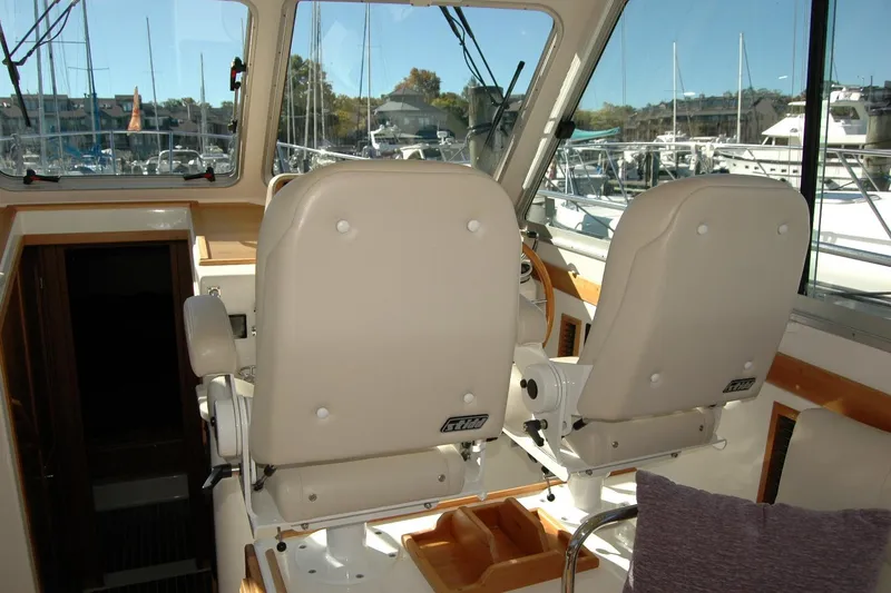 Slide: The Image of Interior of 2015 Back Cove 37 boat with helm seats and marina view. - 39