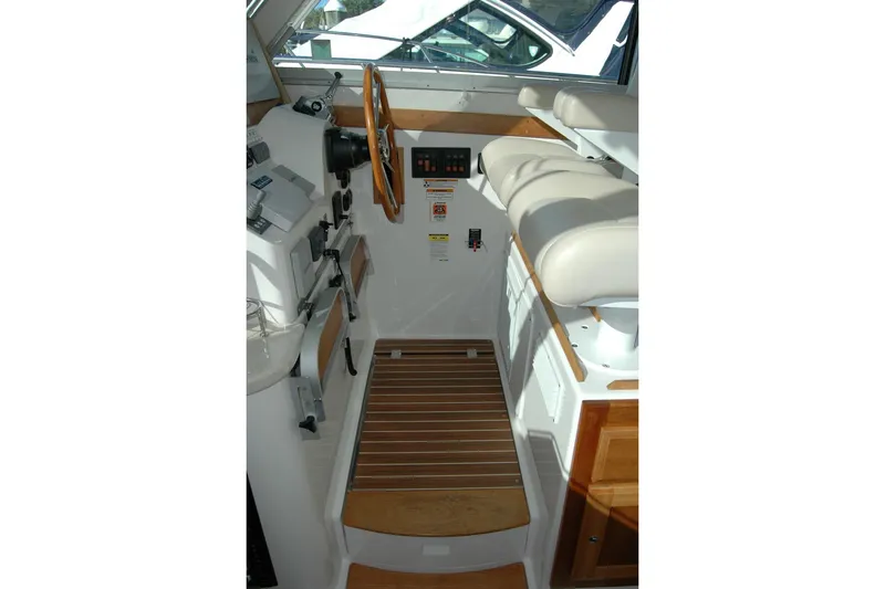 Slide: The Image of Interior helm of 2015 Back Cove 37 boat with wooden accents and controls. - 49