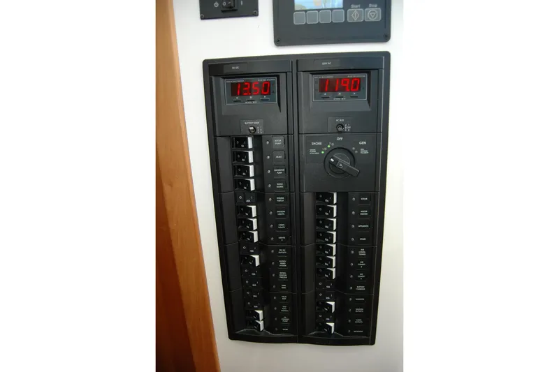Slide: The Image of Electrical control panel on a 2015 Back Cove 37 boat, featuring digital displays and switches. - 57