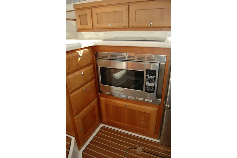 Slide: The Image of Galley kitchen in 2015 Back Cove 37 yacht with microwave and wooden cabinetry. - 60