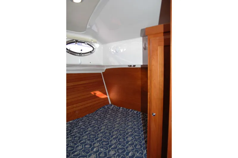 Slide: The Image of 2015 Back Cove 37 interior cabin with wood paneling and patterned bedding. - 70