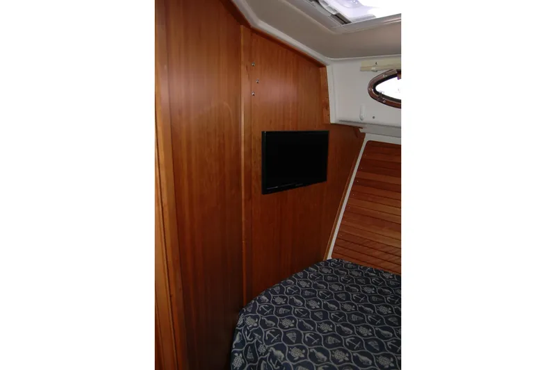 Slide: The Image of 2015 Back Cove 37 cabin interior with wood paneling and mounted TV. - 71