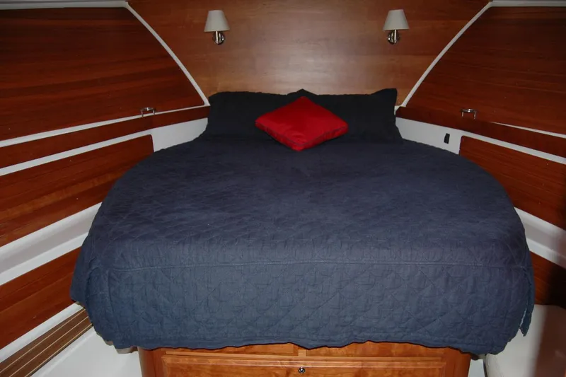 Slide: The Image of Cozy cabin bedroom in 2015 Back Cove 37 yacht with blue bedding and red pillow. - 74