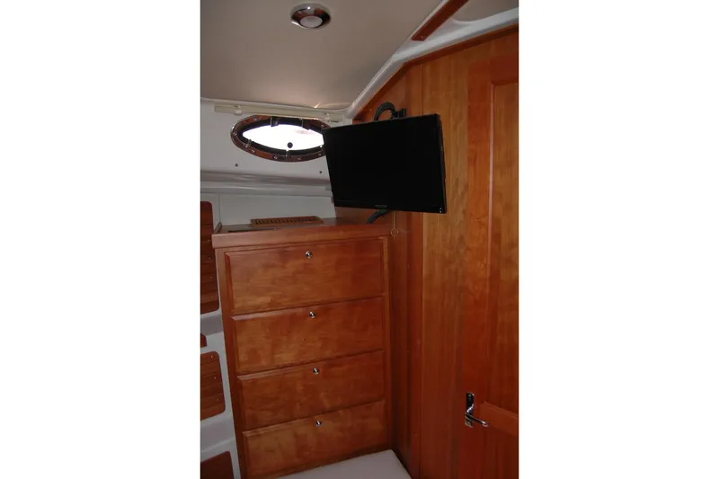 Slide: The Image of 2015 Back Cove 37 interior with wooden cabinetry and mounted TV. - 76