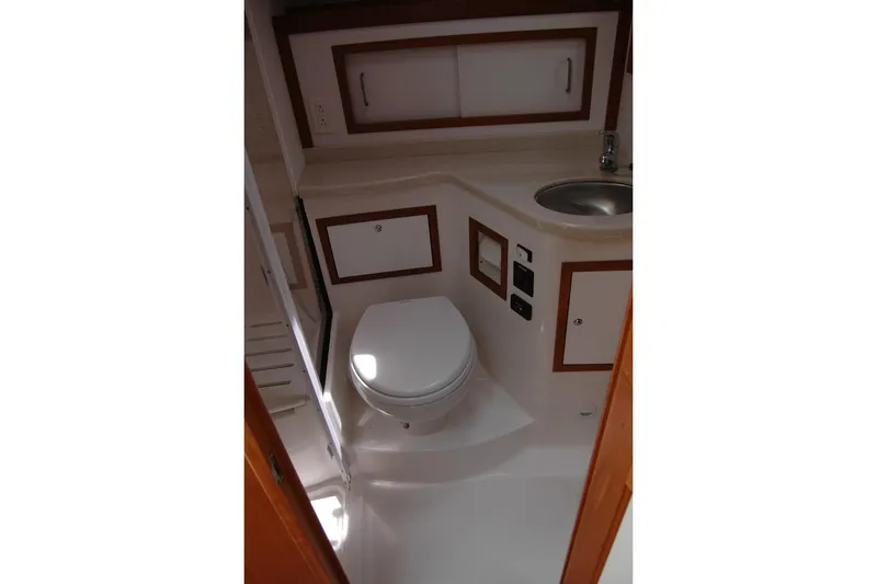 Slide: The Image of 2015 Back Cove 37 yacht bathroom with toilet, sink, and storage cabinets. - 82