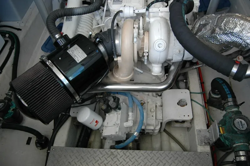 Slide: The Image of Engine compartment of a 2015 Back Cove 37 boat, showcasing mechanical components and piping. - 87