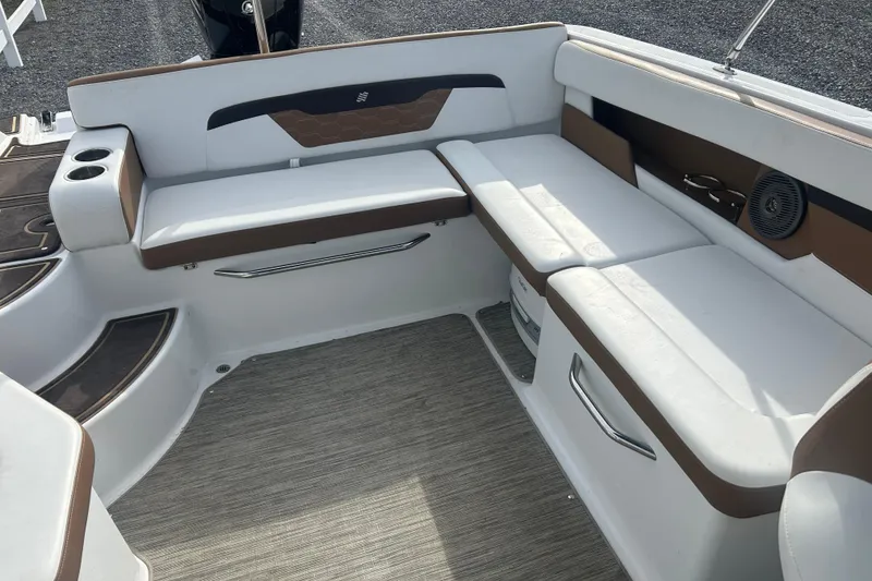Slide: The Image of 2022 Four Winns HD2 OB boat interior with white and brown seating, cup holders, and speaker. - 10