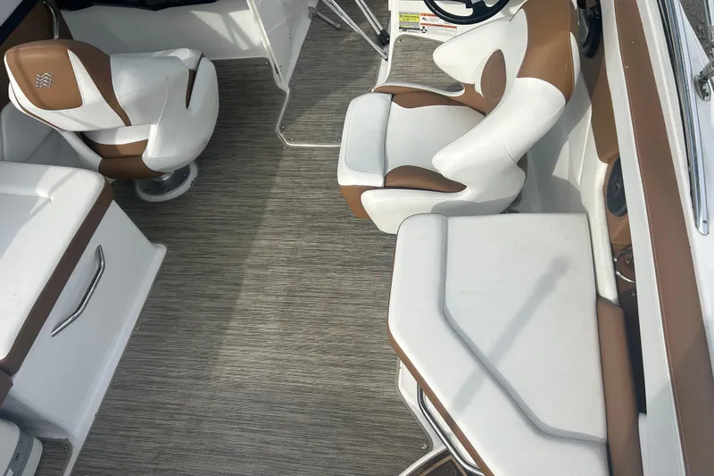 Slide: The Image of 2022 Four Winns HD2 OB boat interior with white and brown seating. - 13