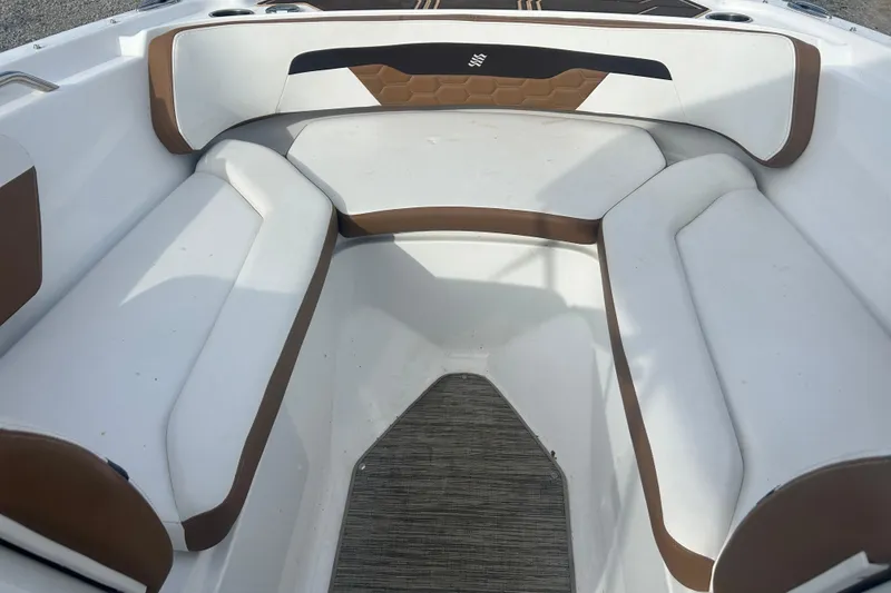 Slide: The Image of 2022 Four Winns HD2 OB boat interior with white and brown seating. - 20