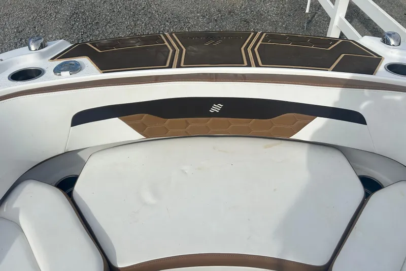 Slide: The Image of 2022 Four Winns HD2 OB boat interior with brown and white seating and cup holders. - 23