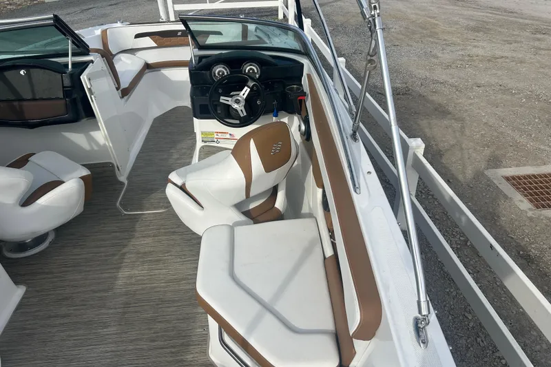 Slide: The Image of 2022 Four Winns HD2 OB boat interior with brown and white seating and steering wheel. - 24