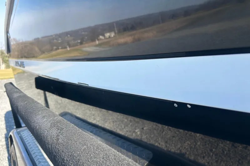 Slide: The Image of 2022 Four Winns HD2 OB boat side view with trailer, outdoors. - 34