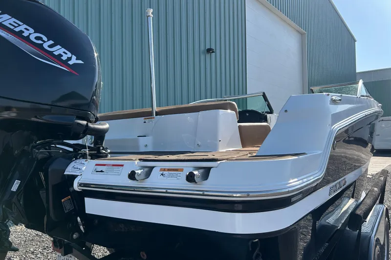 Slide: The Image of 2022 Four Winns HD2 OB boat with Mercury outboard engine, parked near a warehouse. - 35