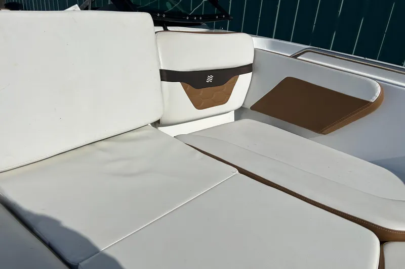 Slide: The Image of 2022 Four Winns HD2 OB boat interior with white and brown seating. - 45
