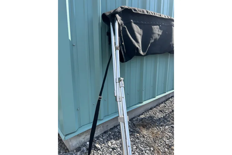 Slide: The Image of Folded bimini top of 2022 Four Winns HD2 OB boat against a blue metal wall. - 49