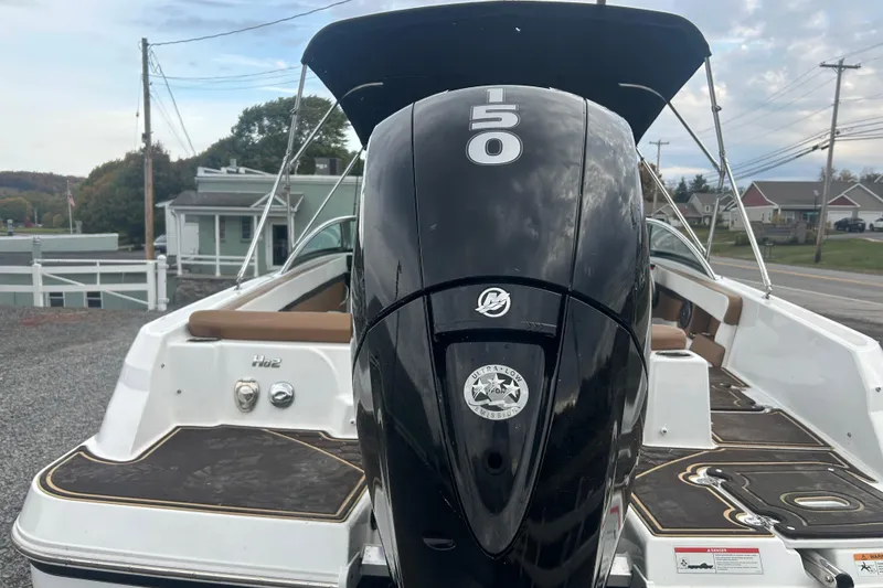 Slide: The Image of 2022 Four Winns HD2 OB boat with a 150 HP outboard motor, docked outdoors. - 9