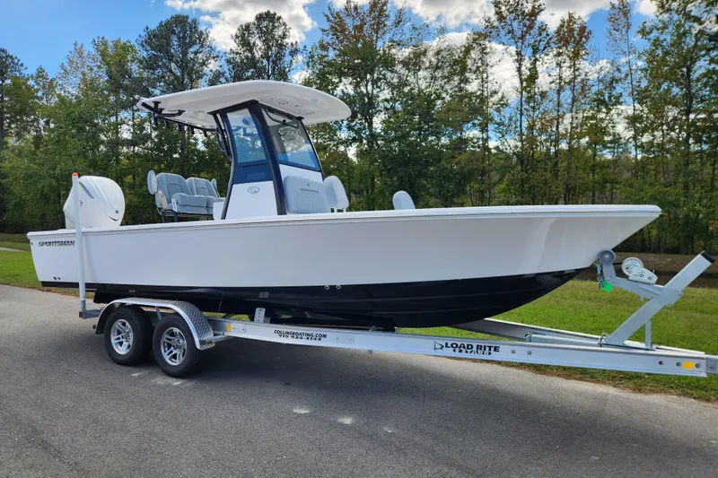 Slide: The Image of 2026 Sportsman Masters 247 Bay Boat on trailer, parked outside a warehouse. - 1