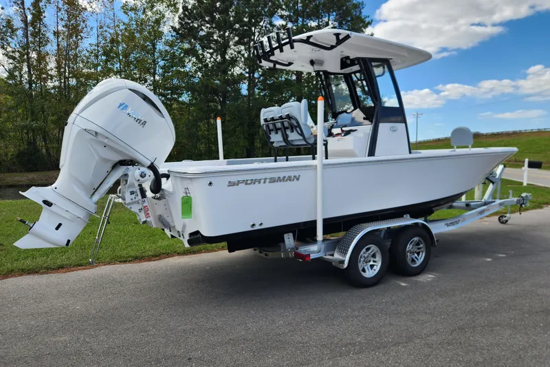 Slide: The Image of 2026 Sportsman Masters 247 Bay Boat with Yamaha engine on trailer, parked outside a building. - 2