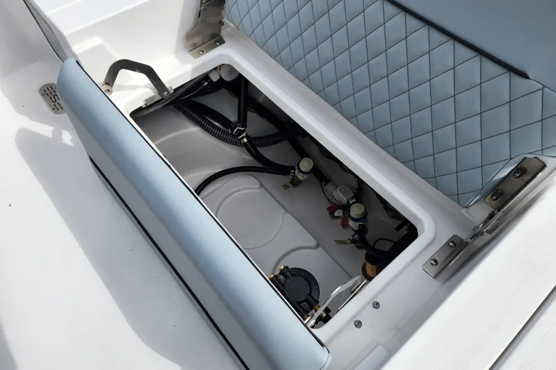 Slide: The Image of 2026 Sportsman Masters 247 Bay Boat storage compartment with blue cushioned seat. - 32