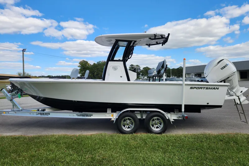 Slide: The Image of 2026 Sportsman Masters 247 Bay Boat on trailer, parked outdoors under blue sky. - 6