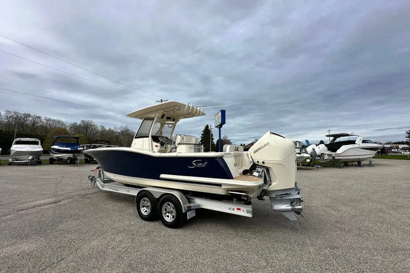 The Image of 2020 Scout 277 LXF boat on trailer, parked outdoors under cloudy sky. - 0