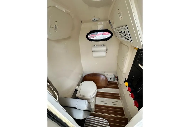 Slide: The Image of 2020 Scout 277 LXF boat interior with toilet and wooden flooring. - 11