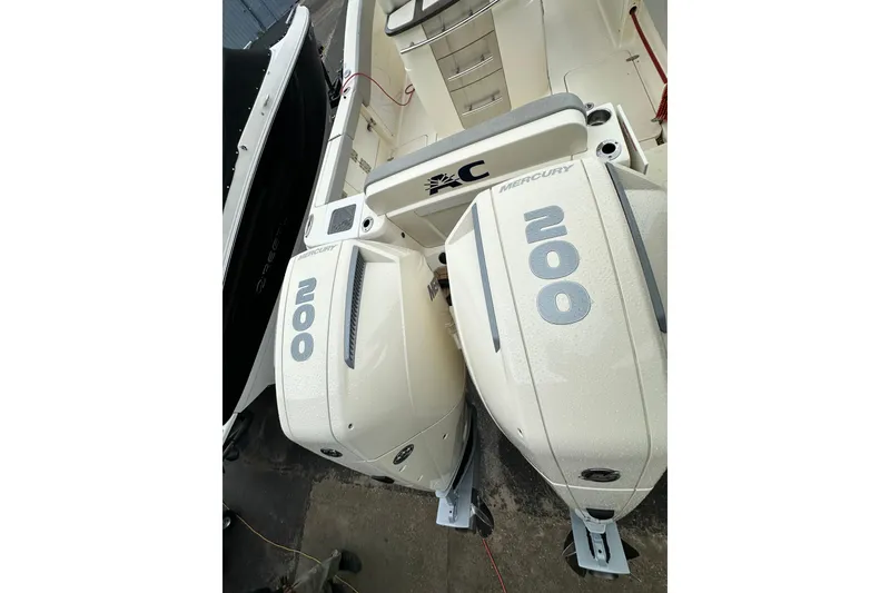 Slide: The Image of 2020 Scout 277 LXF boat with twin Mercury 200 engines, docked in a marina. - 17