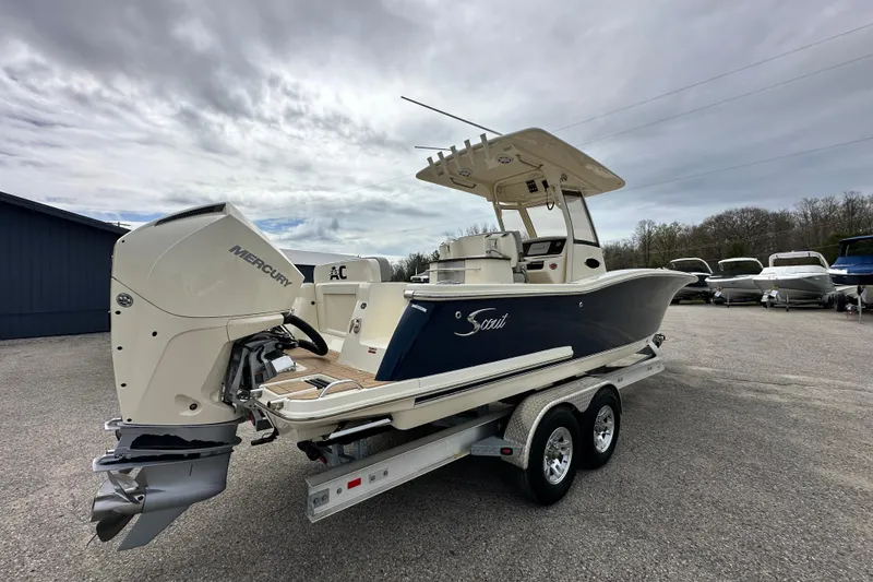 Slide: The Image of 2020 Scout 277 LXF boat with Mercury engine on trailer, parked outdoors. - 2