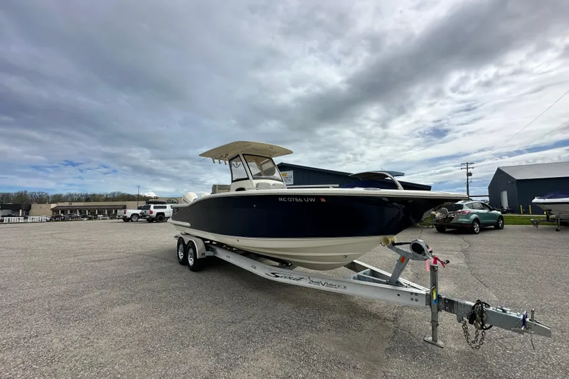 Slide: The Image of 2020 Scout 277 LXF boat on trailer under cloudy sky in parking lot. - 3