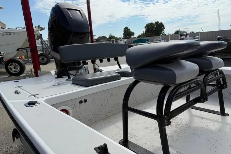Slide: The Image of 2017 Blazer Bay 2420 GTS boat interior with seating and motor, parked outdoors. - 7