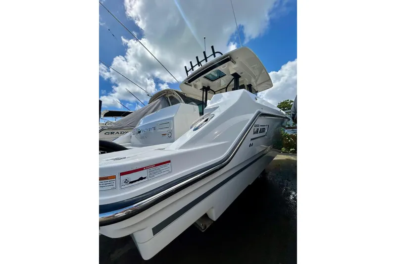 The Image of 2023 Boston Whaler 360 Outrage boat under a bright blue sky with clouds. - 1