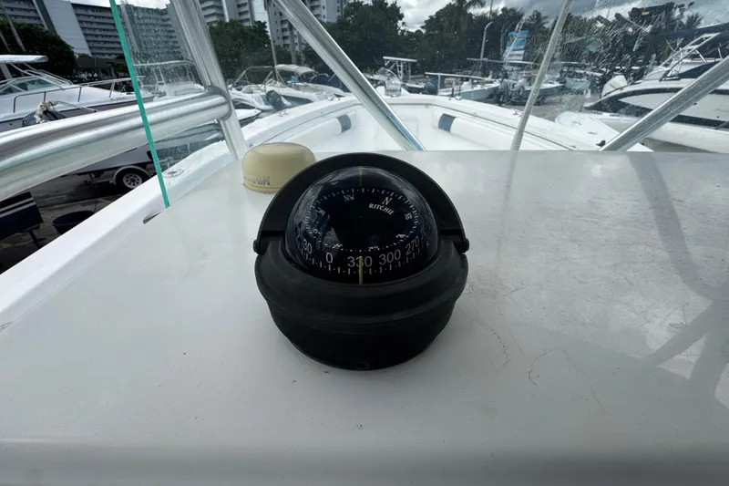 Slide: The Image of Compass on 2008 Sea Fox 287 CC boat dashboard, marina background. - 27