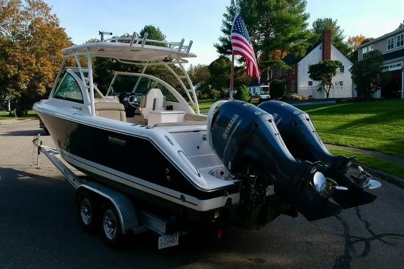 Slide: The Image of 2018 Pursuit DC 265 Dual Console boat on trailer with twin Yamaha engines. - 14