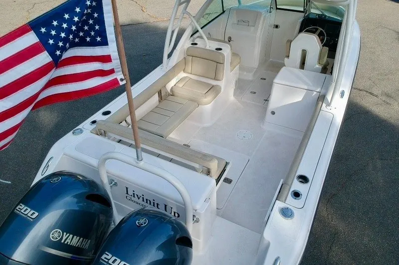 Slide: The Image of 2018 Pursuit DC 265 Dual Console boat with American flag and Yamaha engines. - 16