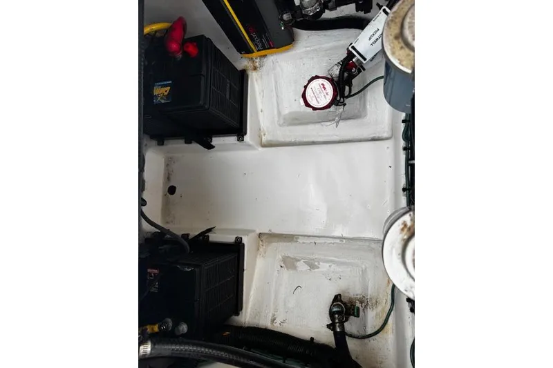 Slide: The Image of 2018 Pursuit DC 265 Dual Console boat interior, showing battery compartments and wiring. - 25