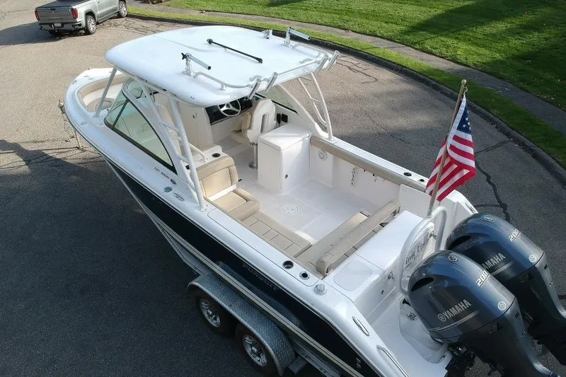 Slide: The Image of 2018 Pursuit DC 265 Dual Console boat with twin Yamaha engines and American flag. - 26