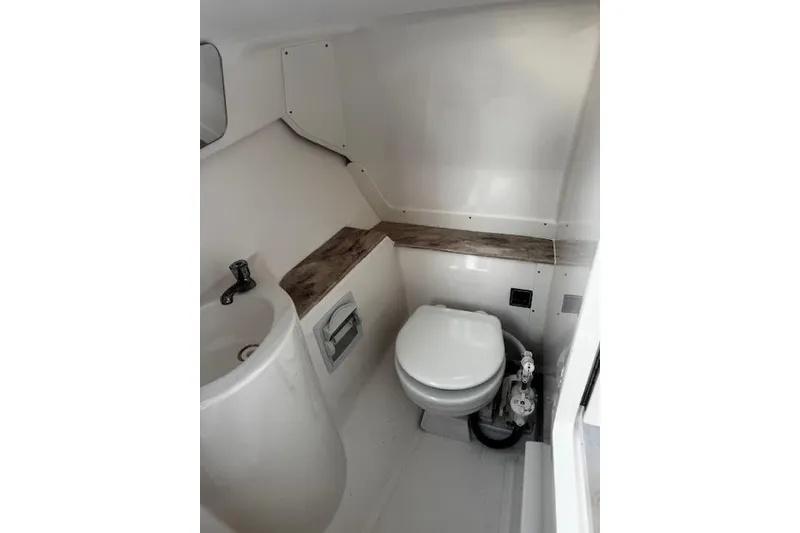 Slide: The Image of 2018 Pursuit DC 265 Dual Console boat bathroom with sink and toilet. - 28