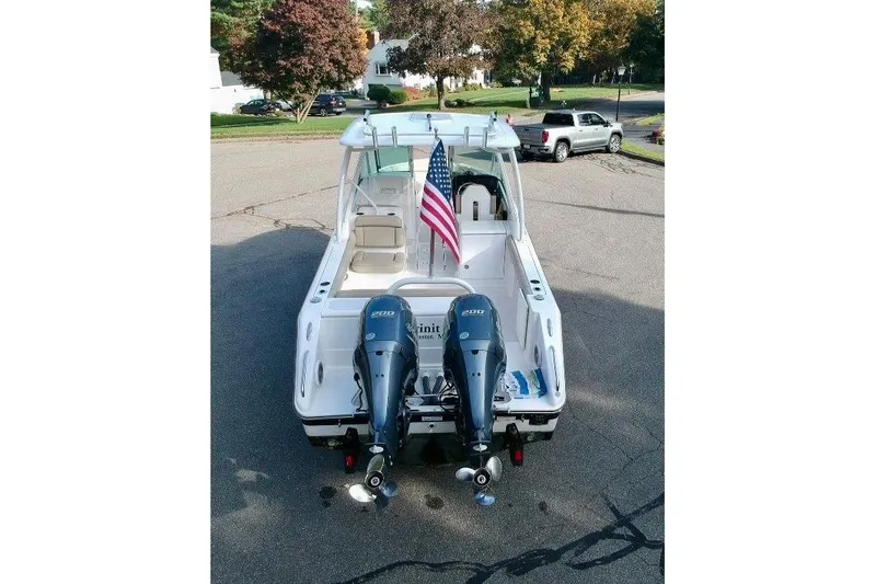 Slide: The Image of 2018 Pursuit DC 265 Dual Console boat with twin engines and American flag. - 3