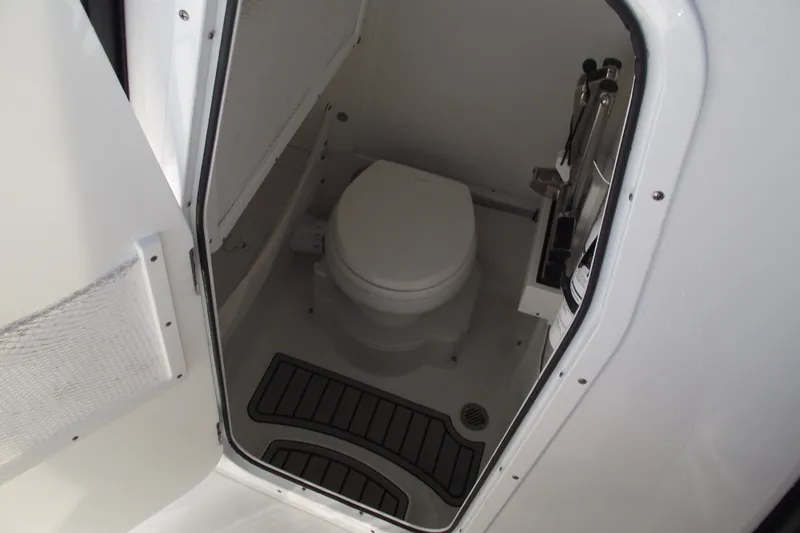 Slide: The Image of 2023 Sea Hunt Ultra 255 SE boat interior bathroom with toilet and compact design. - 18