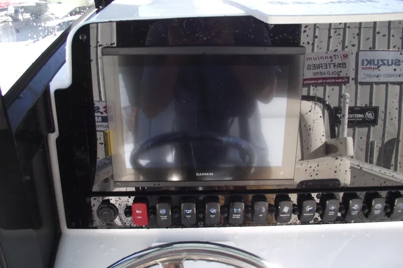 Slide: The Image of 2023 Sea Hunt Ultra 255 SE dashboard with Garmin display and control switches. - 23