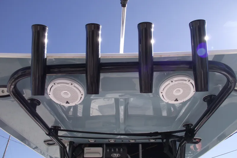 Slide: The Image of 2023 Sea Hunt Ultra 255 SE boat with rod holders and speakers under a clear blue sky. - 27