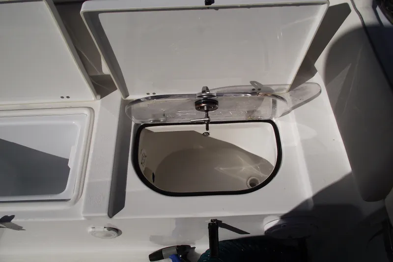 Slide: The Image of 2023 Sea Hunt Ultra 255 SE boat compartment with open lid, showcasing storage space. - 36